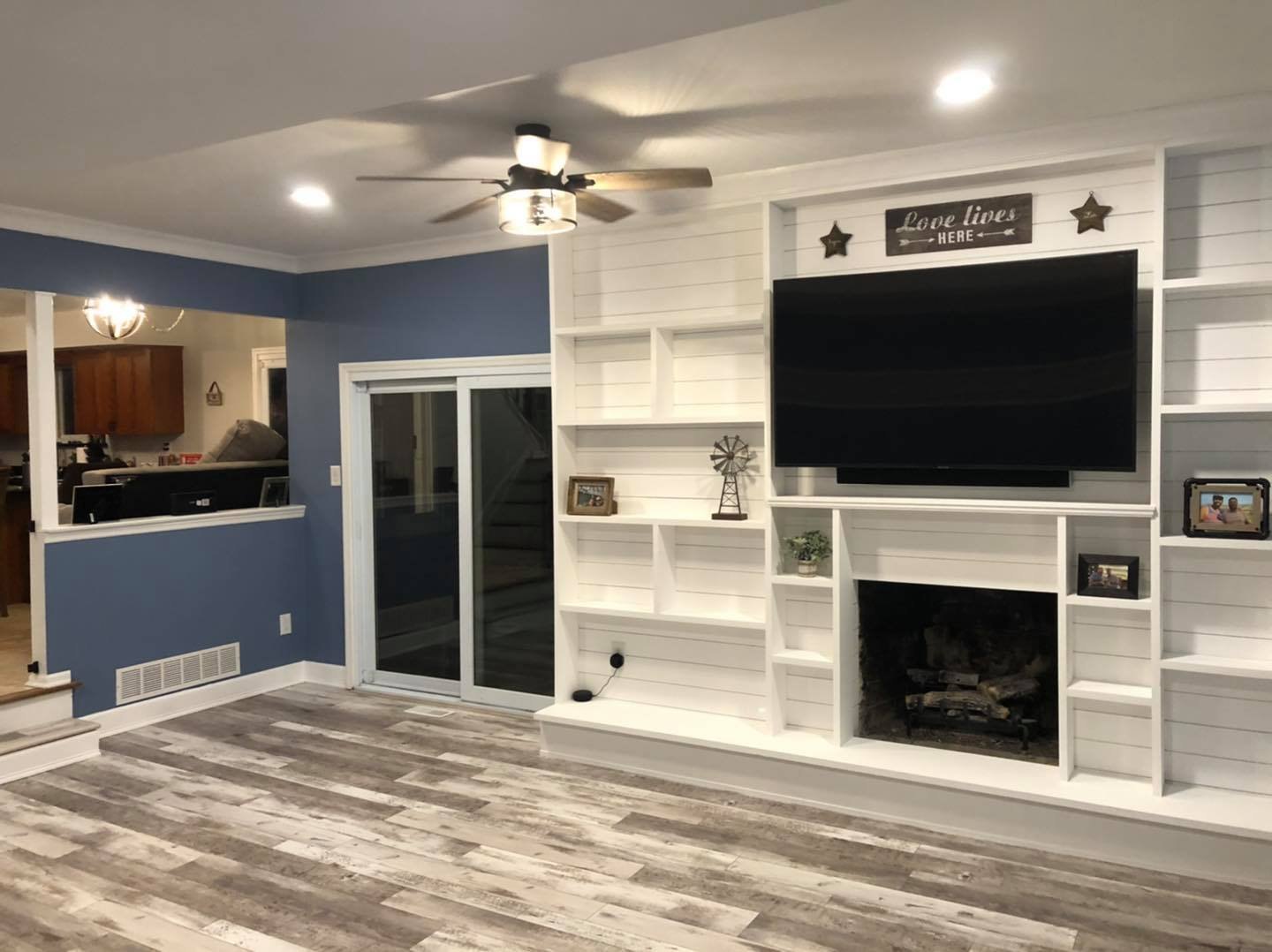 Living room with built-in shelving, fireplace, and new flooring by Doug Does Anything